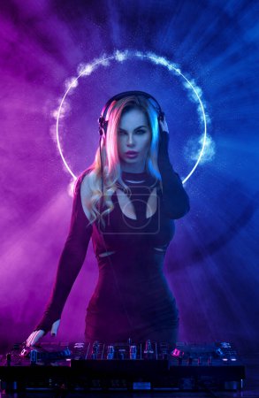 Photo for Girl DJ in neon lights with glasses and headphones. Beautyful woman in violet paint on her face and body. Portrait of sexy TDJ at club party - Royalty Free Image