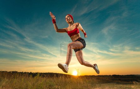 Téléchargez les photos : Sprinter en marche. Femme athlétique forte courant sur fond noir portant des vêtements de sport. Fitness et motivation sportive. Concept de coureur - en image libre de droit