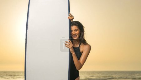 Photo for Girl surfer, vacation in Bali, Indonesia. Download a photo with copy space to advertise tours to a warm country. Surfing and vacation picture for social media - Royalty Free Image