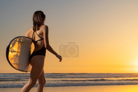Foto de Girl surfer, vacation in Bali, Indonesia. Download a photo with copy space to advertise tours to a warm country. Surfing and vacation picture for social media - Imagen libre de derechos
