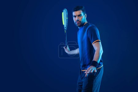 Photo for Squash player on a squash court with racket. Man athlete with racket on court with neon colors. Sport concept. Download a high quality photo for the design of a sports app or betting site - Royalty Free Image