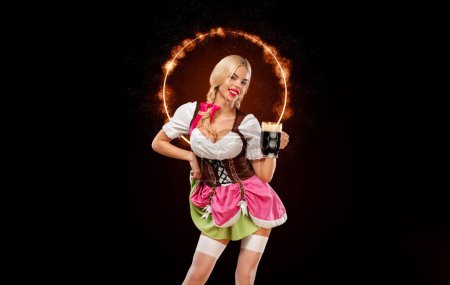 Photo for Half-length portrait of young sexy blonde with big breast wearing color dirndl with white blouse holding the beer mug Isolated on black background - Royalty Free Image