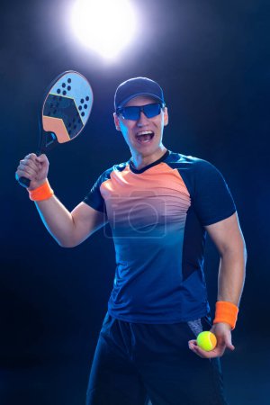 Téléchargez les photos : Joueur de tennis de plage avec raquette. Homme athlète jouer isolé sur fond noir - en image libre de droit