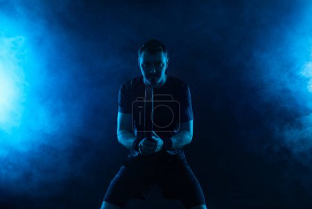 Téléchargez les photos : Joueur de tennis Padel avec raquette. Homme athlète avec raquette sur le terrain avec des couleurs fluo. Concept sportif. Téléchargez une photo de haute qualité pour la conception d'une application sportive ou d'un site de paris - en image libre de droit