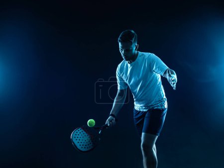 Foto de Tenista de padel con raqueta. Hombre atleta con raqueta en la cancha con colores neón. Concepto deportivo. Descargar una foto de alta calidad para el diseño de una aplicación deportiva o sitio de apuestas - Imagen libre de derechos