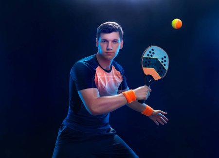 Photo for Beach tennis player with racket. Man athlete playing isolated on black background - Royalty Free Image