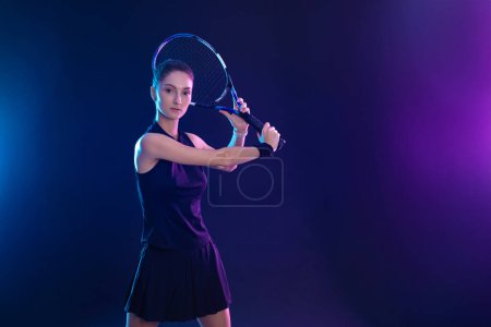 Photo for Tennis player with racket. Girl teenager athlete with racket on court with neon colors. Sport concept. Download a high quality photo for the design of a sports app or betting site - Royalty Free Image