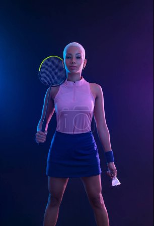 Photo for Badminton player with racket on tournament. Girl athlete with racket on court with neon colors. Sport concept. Download a high quality photo for design of a sports app or tour events - Royalty Free Image