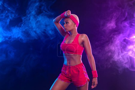 Photo for Sporty fit woman, athlete with dumbbells make fitness exercises on black background. Download cover for music collection for fitness classes. Sports recreation. Beautiful black young woman. - Royalty Free Image