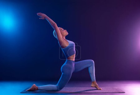 Téléchargez les photos : Download photo for yoga classes ads. Yoga asana Indoor. Sports recreation. Beautiful young woman in yoga pose. Individual sports. - en image libre de droit