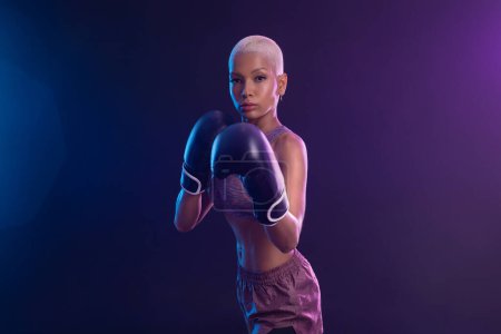 Téléchargez les photos : La boxe. boxeuse brésilienne. boxeur sportif muay thai combat dans des gants. Isolé sur fond noir. Espace de copie - en image libre de droit