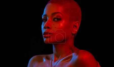 Photo for Creative makeup for Valentines day. Portrait of female fashion model in red neon light on black studio background. Beautiful woman with spring makeup in the shape of small hearts. Beauty concept - Royalty Free Image