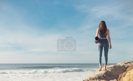 Foto de Mujer practicando yoga al aire libre. Hermosa chica práctica asana en clase online. Tranquilidad y relax. Fondo con salida del sol - Imagen libre de derechos