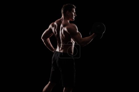 Téléchargez les photos : Jeune homme fort bodybuilder sur fond avec des lumières. - en image libre de droit