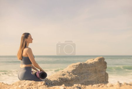 Téléchargez les photos : Femme pratiquant le yoga en plein air. Belle fille pratique asana en classe en ligne. Calme et détente. Contexte avec lever du soleil - en image libre de droit
