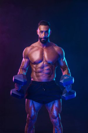 Photo for Athlete bodybuilder in neon colors. Fit man posing on black background. Sports concept. Bodybuilding competition. Download, high resolution, photo - Royalty Free Image