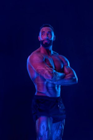 Téléchargez les photos : Bodybuilder athlète en couleurs fluo. Fit homme posant sur fond noir. Concept sportif. La compétition de musculation. Télécharger, haute résolution, photo - en image libre de droit