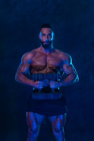 Téléchargez les photos : Bodybuilder athlète en couleurs fluo. Fit homme posant sur fond noir. Concept sportif. La compétition de musculation. Télécharger, haute résolution, photo - en image libre de droit