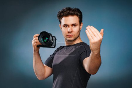 Foto de Joven morena hombre llamando letrero y sosteniendo la cámara en la mano - Imagen libre de derechos