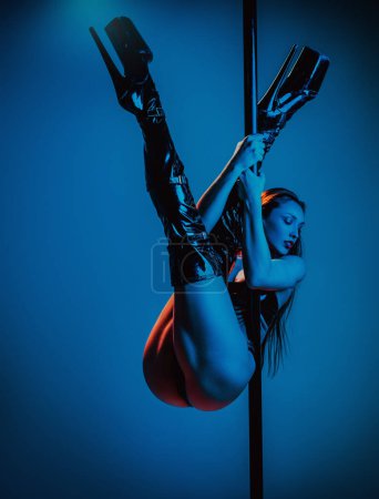 Photo for Young pole dance woman posing on wall background with blue and red lights - Royalty Free Image