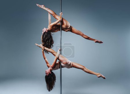 Foto de Dos mujeres de danza de poste delgado sobre fondo de pared blanco - Imagen libre de derechos