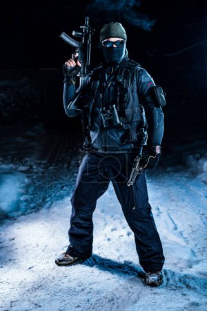 Foto de Fuerte hombre militar fuerzas especiales de pie con armas de fuego en la nieve por la noche - Imagen libre de derechos