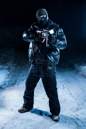 Foto de Fuerte hombre militar fuerzas especiales de pie con arma de fuego en la noche - Imagen libre de derechos