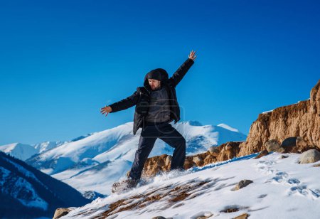 Photo for Young man tourist sliding down from mountain at winter season - Royalty Free Image