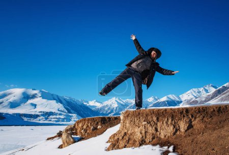 Foto de Joven turista balanceándose sobre rocas en temporada de invierno - Imagen libre de derechos