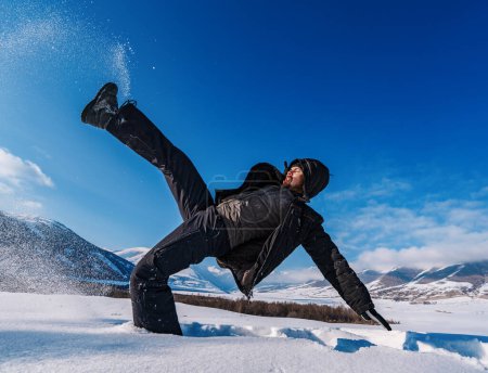 Foto de El hombre resbaló y cayó en la nieve profunda en el fondo de las montañas de invierno - Imagen libre de derechos