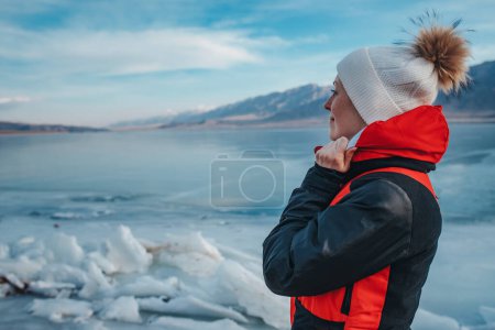 Photo for Young woman tourist looking on frozen lake in Kyrgyzstan at winter season - Royalty Free Image