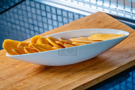 Téléchargez les photos : Table de cuisine avec mangue séchée dans un bol - en image libre de droit