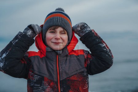Photo for Smiling child winter portrait on lake background - Royalty Free Image