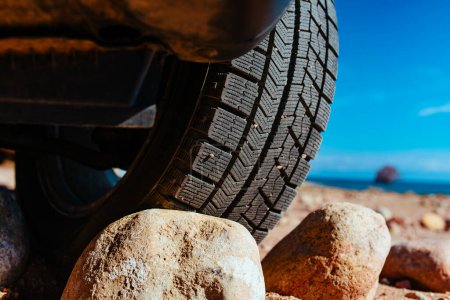 Photo for Car wheel standing on stones close-up view - Royalty Free Image