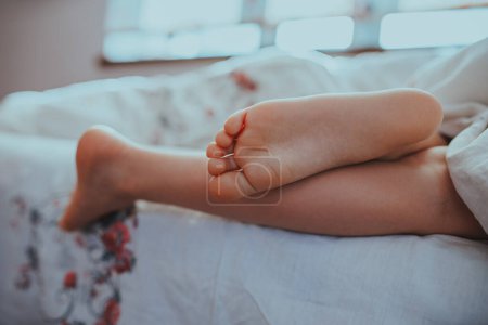 Photo for Feet of a sleeping baby on the bed - Royalty Free Image