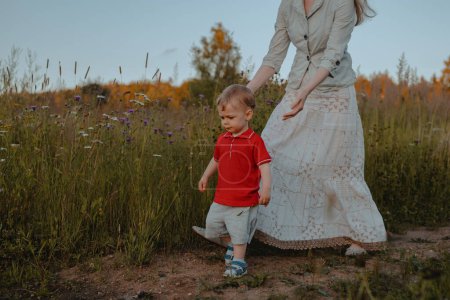 Photo for Mother and her small child walking in a field - Royalty Free Image