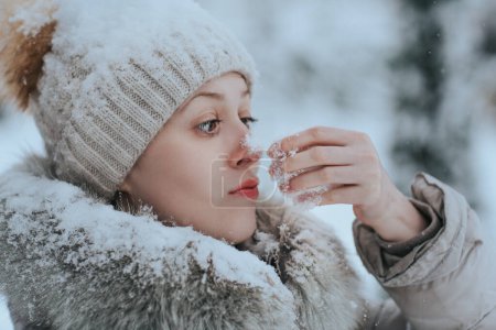 Foto de Retrato de una mujer divertida en ropa de invierno caliente con nieve - Imagen libre de derechos