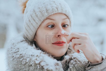 Foto de Retrato de una mujer divertida en ropa de invierno caliente con nieve - Imagen libre de derechos