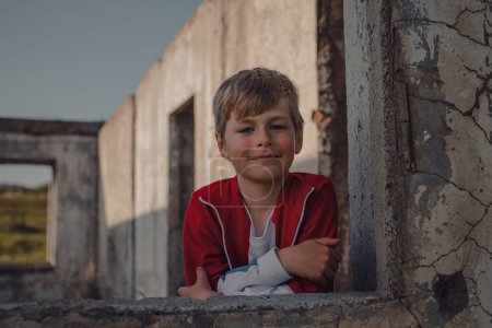 Téléchargez les photos : Portrait de garçon mignon dans un bâtiment en ruine - en image libre de droit