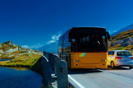Téléchargez les photos : Route des Alpes avec bus de passagers et voiture - en image libre de droit
