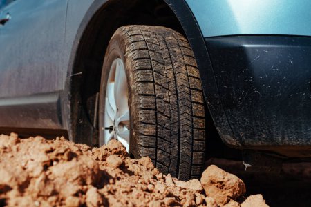 Photo for Car wheel standing offroad on stones and sand close-up view - Royalty Free Image