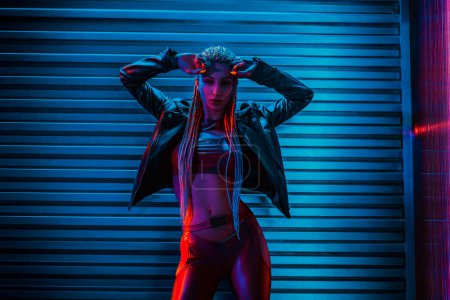 Photo for Young woman dancer posing in dark night club interior with neon lights - Royalty Free Image