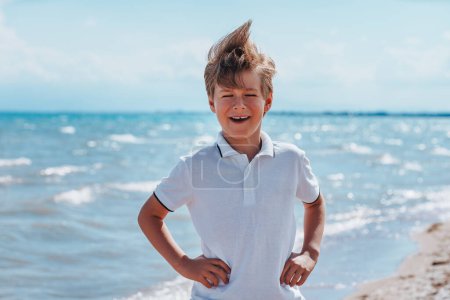 Photo for Portrait of laughing boy at the seaside in windy weather - Royalty Free Image