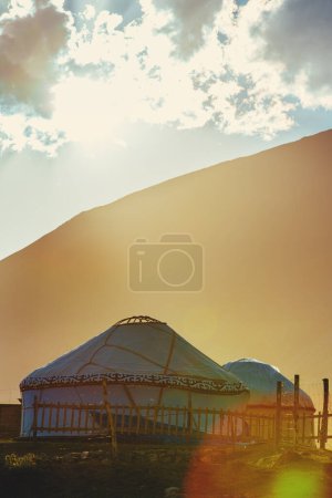 Téléchargez les photos : Yourtes nomades dans les montagnes au coucher du soleil, Kirghizistan - en image libre de droit