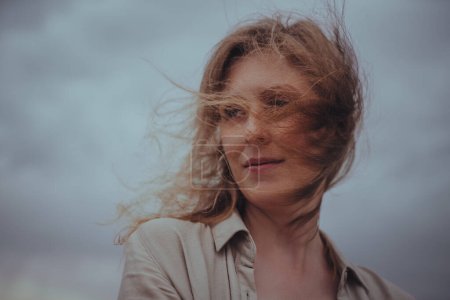 Téléchargez les photos : Portrait romantique de belle jeune femme avec les cheveux flottants sur le vent - en image libre de droit