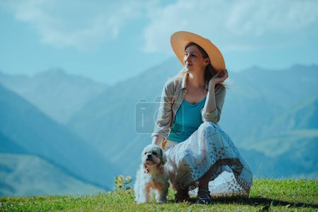 Foto de Hermosa mujer elegante con shih tzu perro sobre fondo de montaña - Imagen libre de derechos