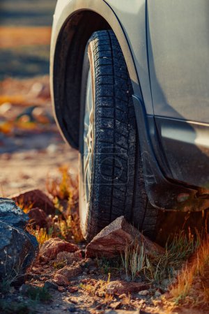 Photo for Car wheel standing offroad on stone close-up view - Royalty Free Image