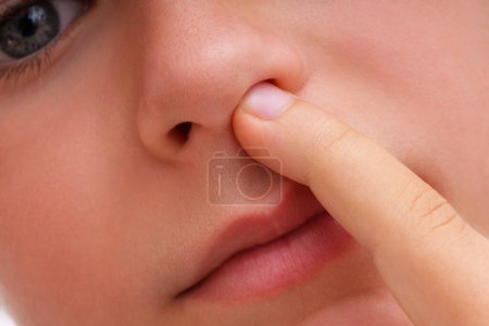 Foto de El bebé coge su nariz con su dedo cerca de la vista - Imagen libre de derechos