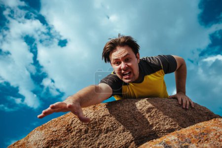 Photo for Male hiker on edge of cliff afraid to fall down, emotional portrait - Royalty Free Image