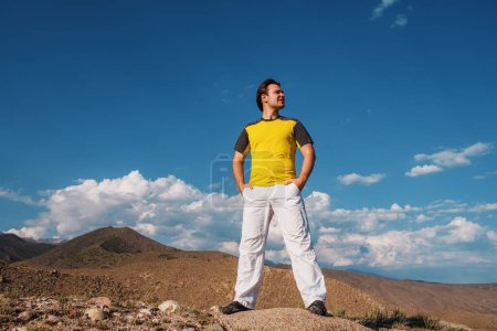 Photo for Handsome young man standing on mountains background and looking away - Royalty Free Image